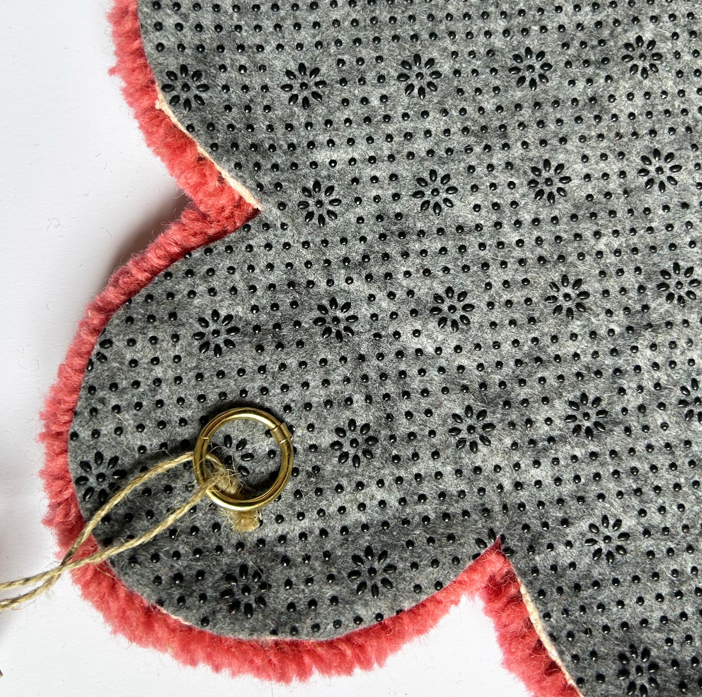 Petite fleur rouge pale en tufting.