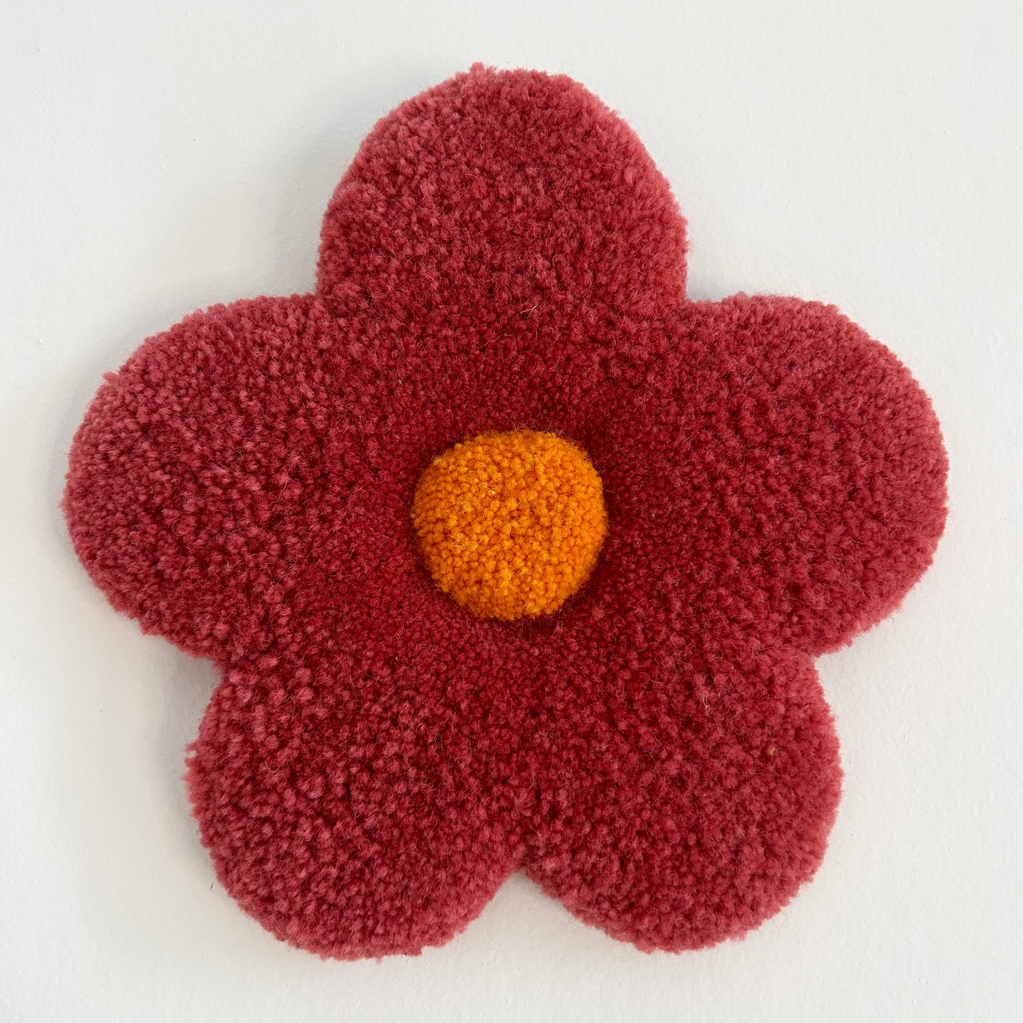 Petite fleur rouge pale en tufting.