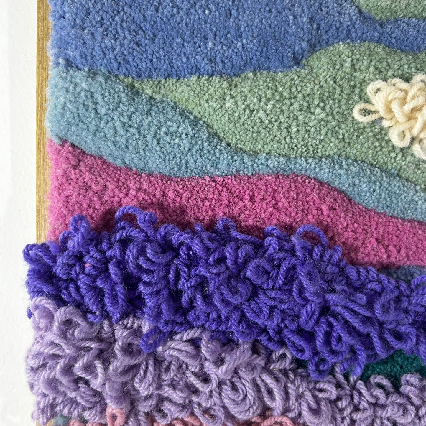Cadre bleu, violet et rose en tufting.