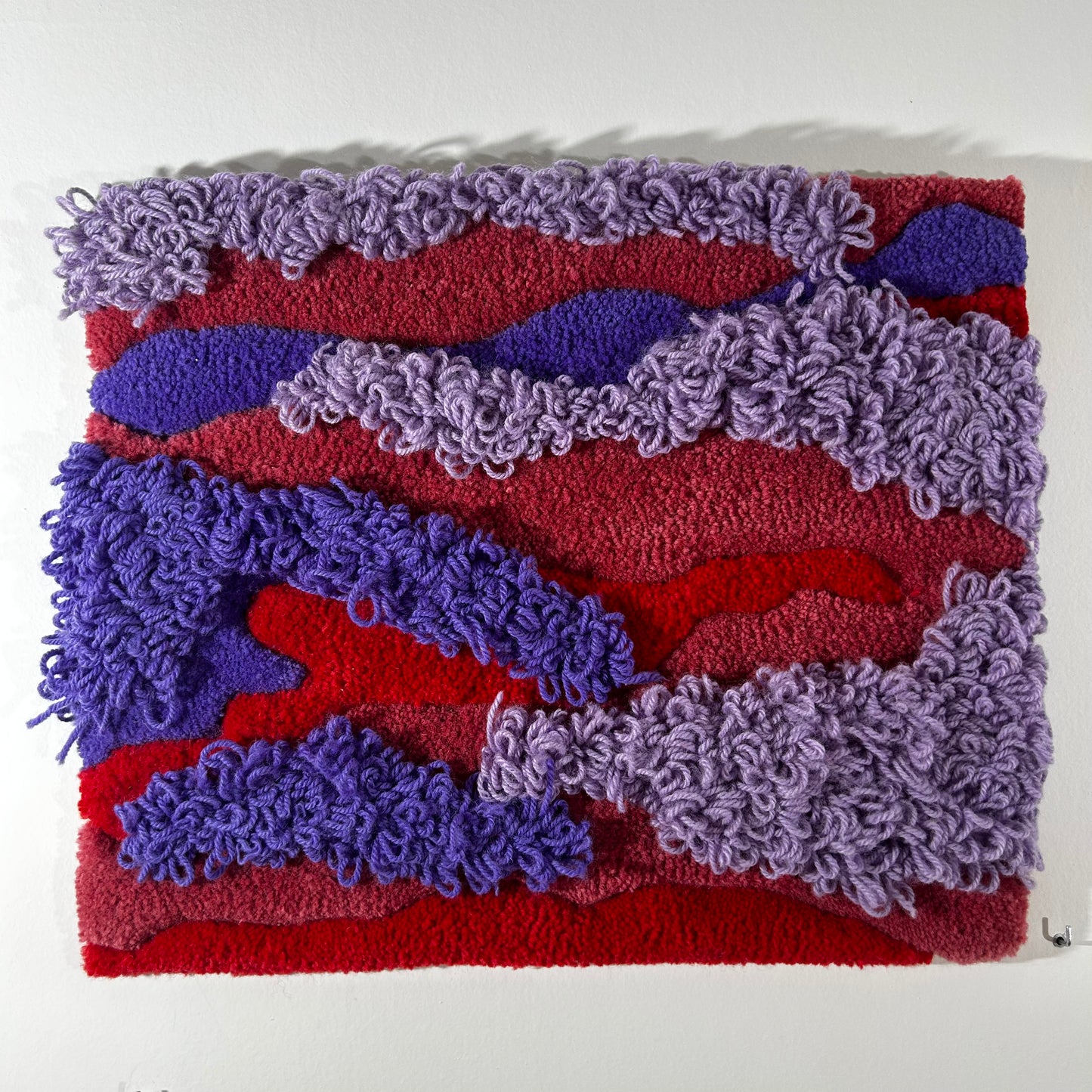 Tableau violet, rouge et lilas en tufting.